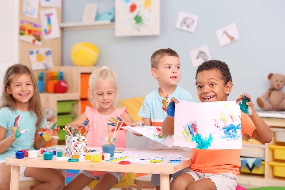 Children painting together at preschool